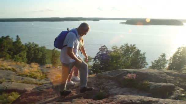 Anciana pareja activa escalando en la roca y admirando el amanecer, el atardecer . — Vídeo de stock