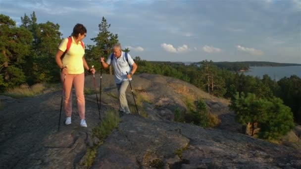 Elderly active couple climbing on the rock and admiring the sunrise, the sunset. — Stock Video