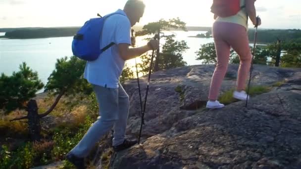 Ältere aktive Paar klettert auf den Felsen und bewundert den Sonnenaufgang, den Sonnenuntergang. — Stockvideo