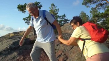 Sunrise, Sunset ile kayaya yaşlı aktif Çift.