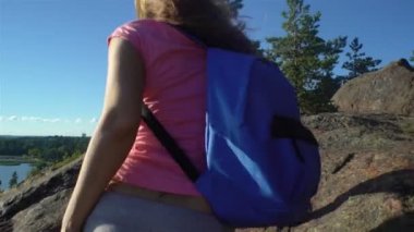 İki aktif genç kadınlara yüksek bir kaya tırmanmaya yardım