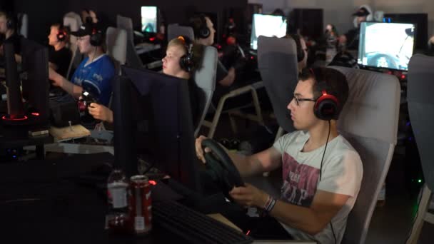 Los adolescentes están jugando en la carrera de coches con la rueda de una consola de juegos . — Vídeos de Stock