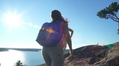 İki aktif genç kadınlara yüksek bir kaya tırmanmaya yardım