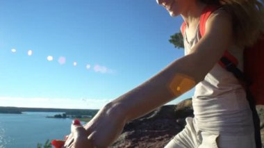 İki aktif genç kadınlara yüksek bir kaya tırmanmaya yardım