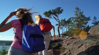 İki aktif genç kadınlara yüksek bir kaya tırmanmaya yardım