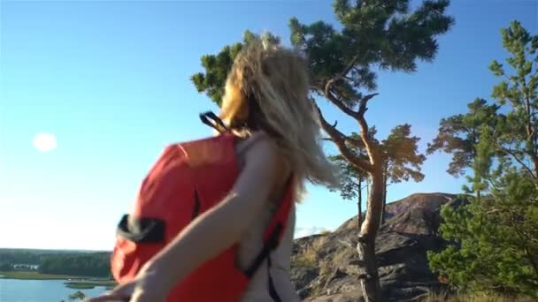 Νεαρή γυναίκα που οδηγεί έναν άνθρωπο να αναρριχηθεί ψηλό άγριο βράχο. — Αρχείο Βίντεο