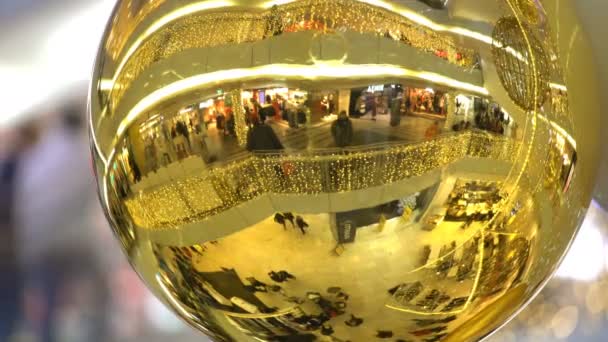 Багато покупців в торговому центрі відбивається в Золотий м'яч Різдво. — стокове відео