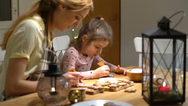 Ung mamma och hennes lilla dotter förbereda julkakor — Stockvideo