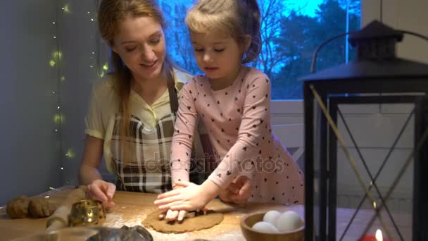 Молодая мать и ее маленькая дочь готовят рождественское печенье — стоковое видео