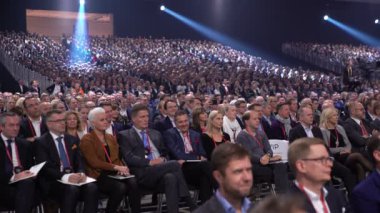 Büyük bir izleyici için hoparlör dinler.