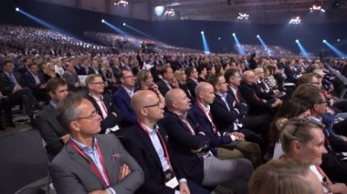 Büyük bir izleyici için hoparlör dinler.