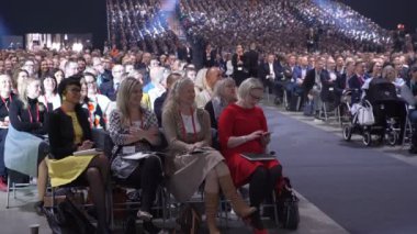 Büyük bir izleyici için hoparlör dinler.