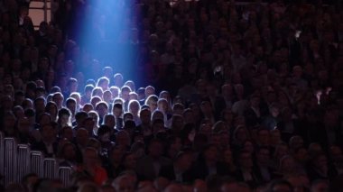 Büyük bir izleyici için hoparlör dinler.