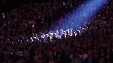 Büyük bir izleyici için hoparlör dinler.