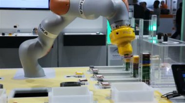 Kompakt bir endüstriyel esnek robotik kol nesneleri renklerine göre dağıtır..