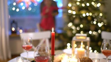 Genç bir kadın mumları Noel masada ışıklar..