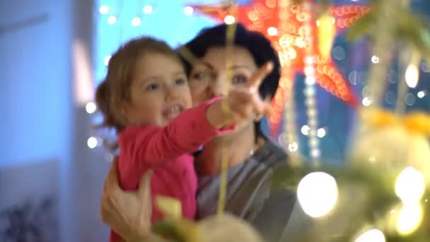Abuela y nieta decoran el árbol de Navidad en el interior — Vídeos de Stock