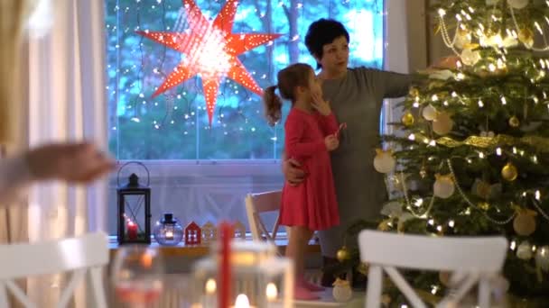 若い女性はクリスマスのテーブルにキャンドルを点灯します。. — ストック動画