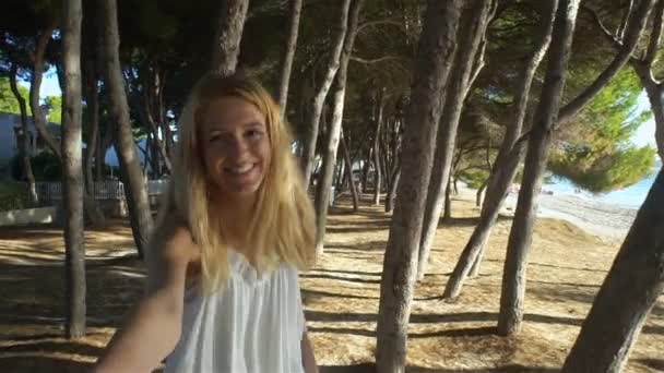 Bella giovane donna che indossa abito bianco tenendosi per mano e portando il suo amico sul molo — Video Stock