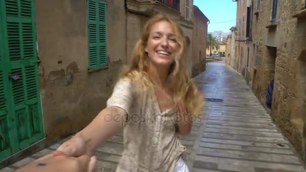 Une jeune femme mène un homme à l'aventure dans une vieille ville européenne . — Video