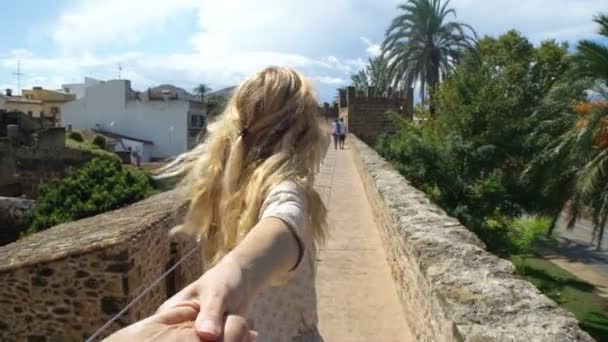 Νεαρή γυναίκα που οδηγεί έναν άνθρωπο να την περιπέτεια σε μια παλιά ευρωπαϊκή πόλη. — Αρχείο Βίντεο