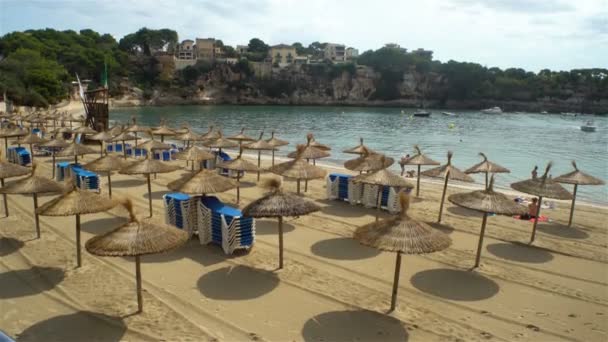 Guarda-chuvas de palha na praia de Porto Cristo em Maiorca, Espanha — Vídeo de Stock