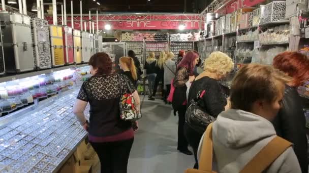 Muchas mujeres probando y comprando cosméticos en una tienda de belleza . — Vídeos de Stock