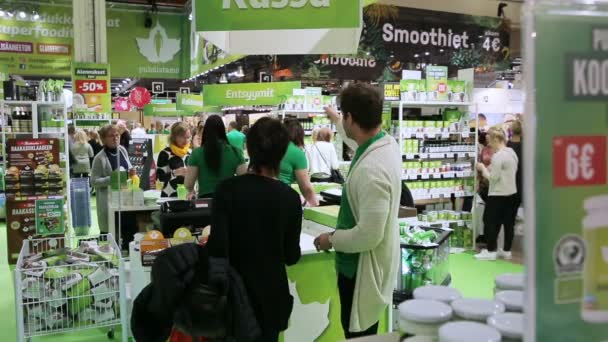 Посетители магазина экологически чистых продуктов питания попробовать органические смеси энергии . — стоковое видео