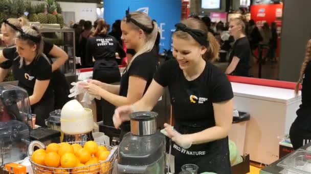 Junge Frauen, die an der Saftbar arbeiten und Früchte schneiden. Barkeeperinnen machen frischen Saft. — Stockvideo