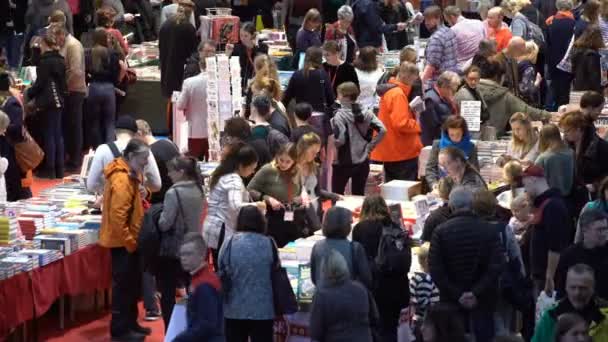 Muchos amantes de la lectura, compradores, editores y libros en la gran feria del libro . — Vídeo de stock