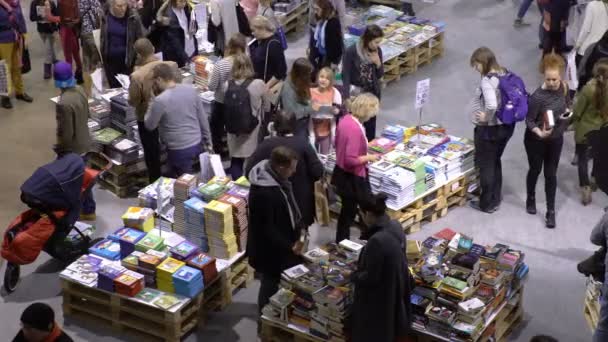 Vele liefhebbers van lezen, kopers, uitgevers en boeken op de grote boekenbeurs. — Stockvideo