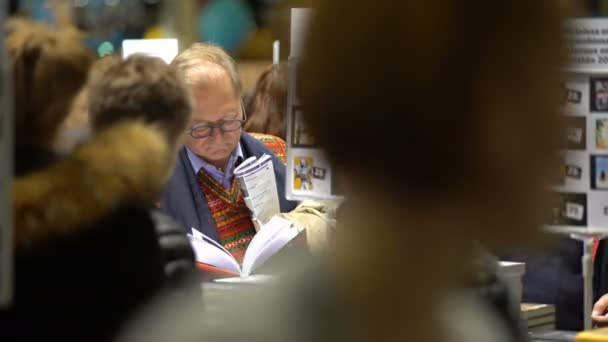 Vele liefhebbers van lezen, kopers, uitgevers en boeken op de grote boekenbeurs. — Stockvideo