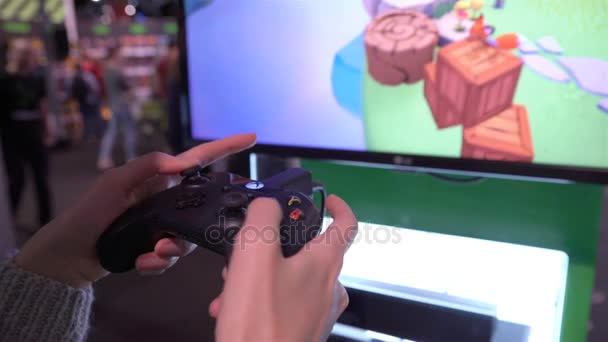 Jonge vrouw spelen nieuwe degenen Xbox One X met behulp van een gamepad. — Stockvideo