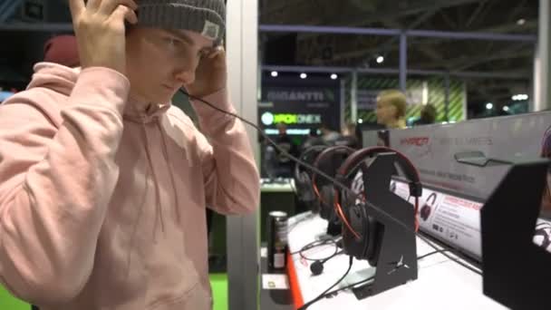 Mladý muž testování nové sluchátka v obchodě. — Stock video
