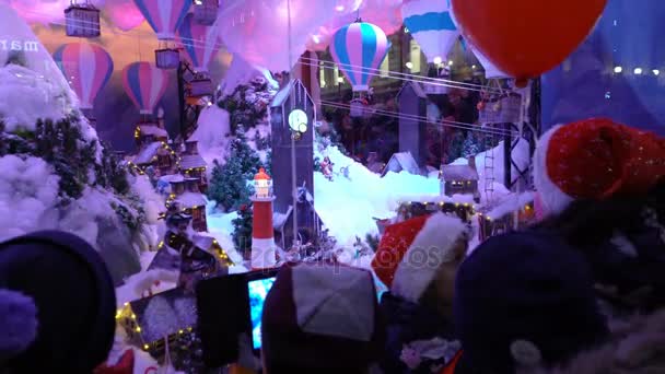 Εμφανίζει τα παιδιά θαυμάζοντας το παράθυρο διακοπών Χριστουγέννων — Αρχείο Βίντεο