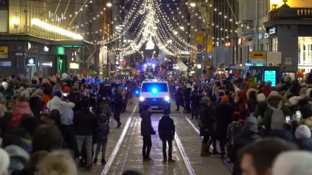 Politie-auto met knipperende lampjes langzaam bewegen onder de feestelijke menigte — Stockvideo