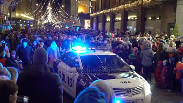 Auto della polizia con luci lampeggianti lentamente in movimento tra la folla festosa — Video Stock
