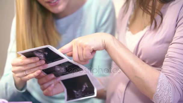 Femme enceinte et son ami considèrent photo échographie 3D bébé dans l'utérus . — Video