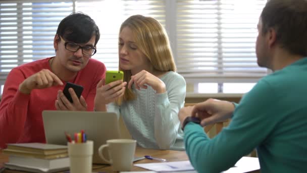 Молодые люди используют различные электронные устройства в офисе . — стоковое видео