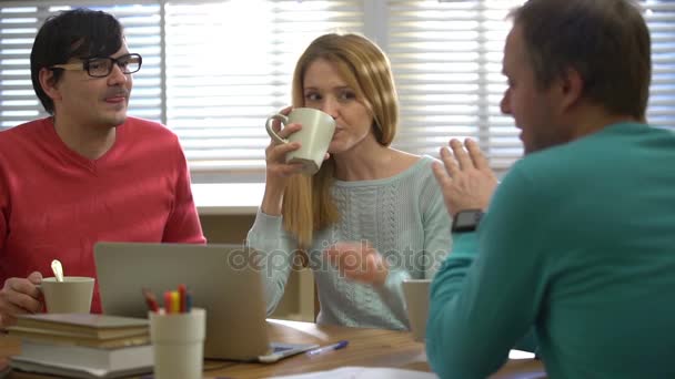 Una pausa para el café. Jóvenes tomando café y hablando en la oficina . — Vídeo de stock