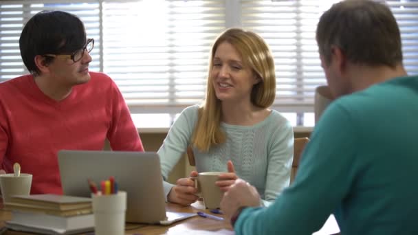 Una pausa para el café. Jóvenes tomando café y hablando en la oficina . — Vídeo de stock