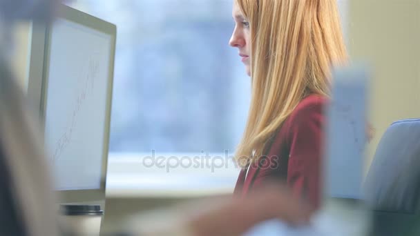 Jeune femme attrayante travaillant avec un ordinateur dans le bureau .