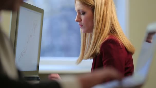 Ofiste bir bilgisayarla çalışan genç çekici kadın. — Stok video