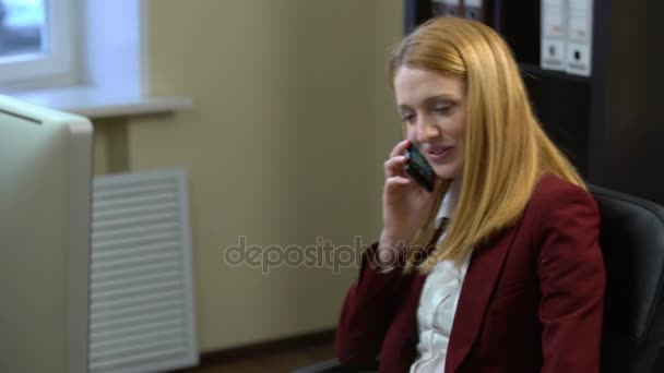 Businesswoman talking on his mobile phone and drinking coffee in the office. — Stock Video