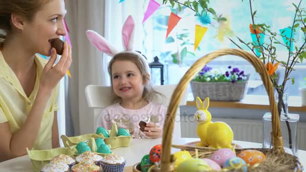 Moeder en dochter eten chocolade paaseieren — Stockvideo