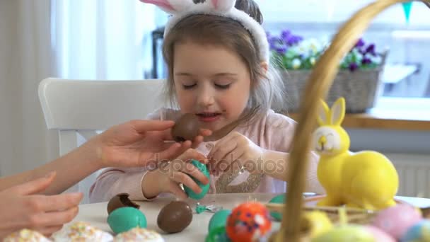 Маленька дівчинка їсть шоколадні великодні яйця — стокове відео