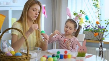 Mutlu Paskalya anne ve küçük kızı Paskalya yumurta boyama