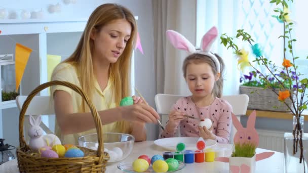 Happy Easter Mother and her little daughter coloring easter eggs — Stock Video