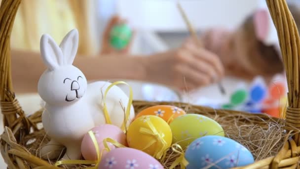 Glückliche Ostermutter und ihre kleine Tochter beim Ostereierfärben — Stockvideo