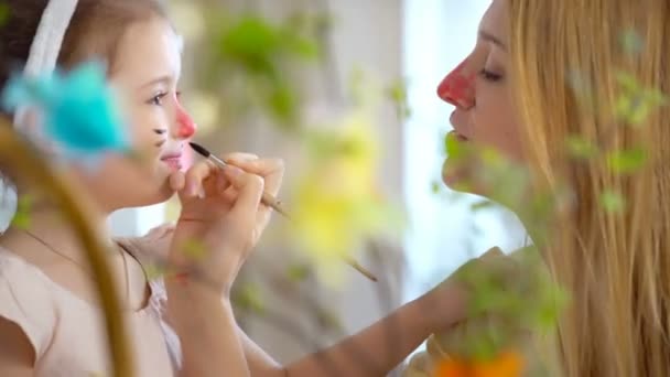 Boldog húsvéti anya és lánya birtoklás móka és a festék egymás arcát nyuszik — Stock videók